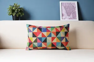 Detail von buntem geometrischem Kissenbezug mit Dreiecksmuster auf weißem Sofa