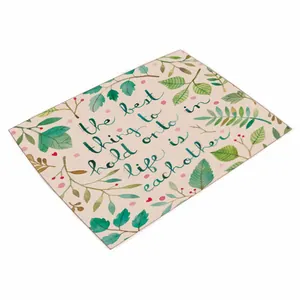 Detail van de placemat met tropische bladeren en een inspirerende Engelse tekst erop