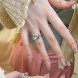 Detail shot of niche lava style moonstone open ring with colorful zircons on a hand.