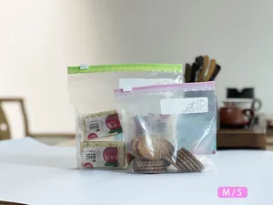 Close-up of reusable slider storage bags containing biscuits and snacks