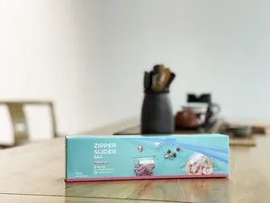 Detail shot of teal zipper slider bag box on a wooden kitchen table
