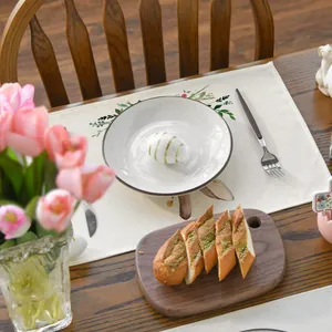 Detailed close-up of a botanical linen placemat set on a warm wooden dining table