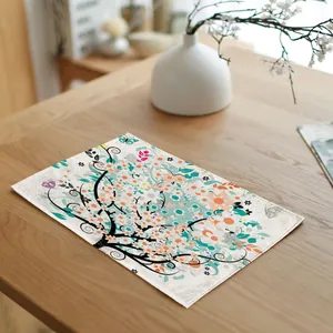 Rectangular linen fabric placemat with colorful floral tree pattern on a wooden dining table