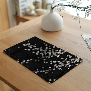 Dichtbij van zwarte linnen placemat met witte kersenbloesem patroon op houten tafel