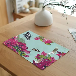 Floral and butterfly pattern linen placemat on a wooden dining table with a silver fork