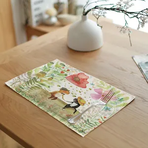 Detailed view of a linen placemat featuring a charming spring meadow and cat illustration.