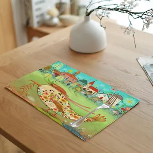 Detail view of linen placemat with artistic floral bird illustration on wooden table