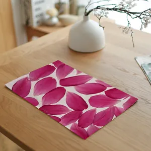 Detail van linnen placemat met levendig roze bloemblaadjesontwerp op een houten tafel