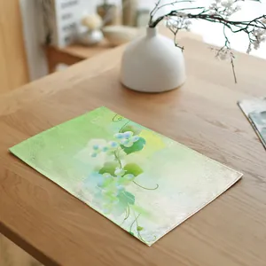 Elegante linnen placemat met groene botanische bloemenprint op een houten eettafel