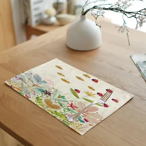 Linen placemat detail with vibrant ladybug and bee spring pattern on wooden table