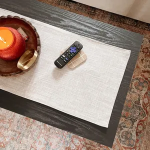 Detailed close-up view of a thickened cream linen table runner on a dark coffee table