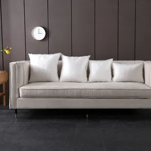 Row of white pillow inserts of different sizes displayed on a plush beige sofa