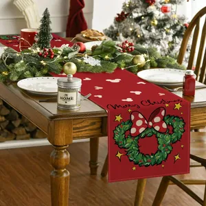 Primer plano de camino de mesa navideño rojo con corona estilo Minnie