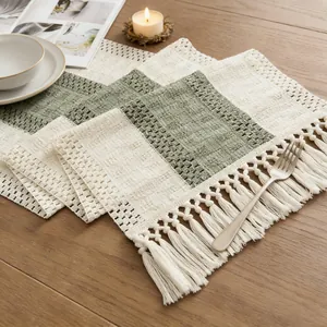 Close-up of rustic linen table runner with sage green checks and tassel trim