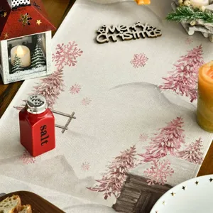 Camino de mesa navideño rosa con motivos de abetos y copos en un ambiente festivo
