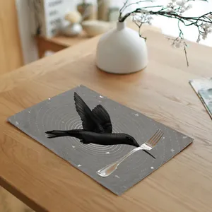 Linen placemat with black hummingbird print on a wooden dining table