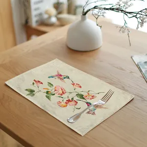 Detailed view of linen placemat featuring watercolor hummingbird and floral patterns