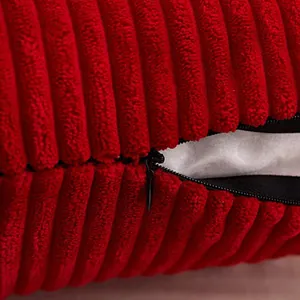 Detailopname van rode corduroy kussenhoes met een verborgen rits en zachte ribbeltextuur
