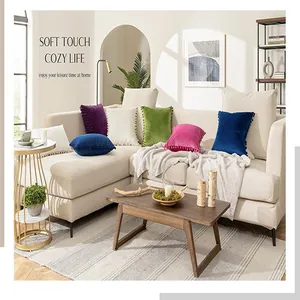 Set of colorful velvet pompom cushion covers for sofa in a cozy minimalist home interior