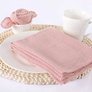Detailed view of soft pink slub cotton napkin with hemmed edges on a white plate