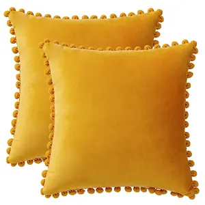 Set of 2 velvet throw pillow covers with decorative pom-pom fringe in mustard yellow.