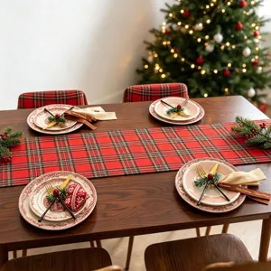 Détail d'un chemin de table de Noël à carreaux rouges sur une table festive