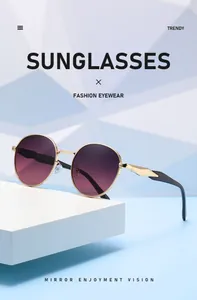 Nahaufnahme modischer Rundrahmen-Sonnenbrille mit lila Verlaufsgläsern und goldenen Bügeln