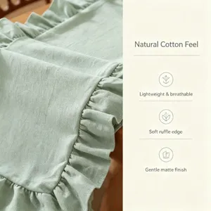 Gros plan d'un chemin de table vert sauge à volants, texture coton doux