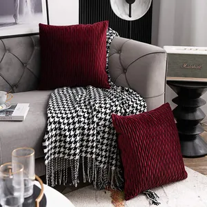 Detailed view of burgundy pleated velvet throw pillow covers on a luxury grey sofa