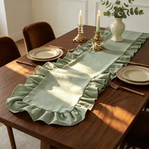 Détail de la texture d'un chemin de table vert sauge à volants sur table