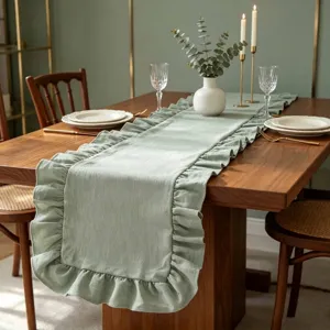 Chemin de table élégant vert sauge avec bordures à volants sur table en bois