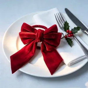 Red velvet bow napkin ring detail for Christmas table settings on a white plate
