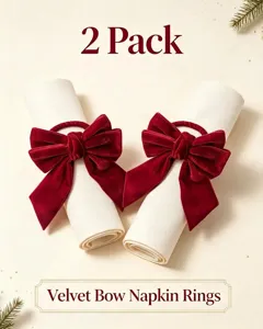 Detail of two red velvet bow napkin rings on white napkins for holiday decor.