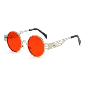 Lunettes de soleil steampunk rondes avec monture en métal évidé et verres rouges vifs.