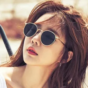 Gros plan d'une femme portant des lunettes de soleil ovales en métal chic
