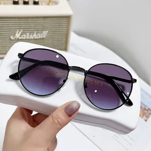 Lunettes de soleil ovales en métal avec verres dégradés violets sur un étui rigide blanc