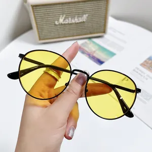 Vue détaillée de lunettes de soleil ovales tendance avec verres jaunes et monture en métal noir
