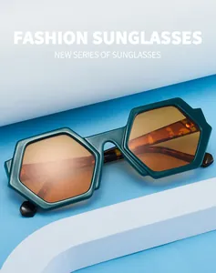 Close-up of stylish green hexagonal sunglasses with orange lenses on blue background
