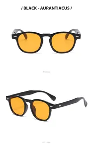 Detailed view of retro round black sunglasses with orange lenses and metal rivets