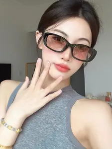 Gros plan de lunettes de soleil rectangulaires noires tendance avec verres dégradés sur une femme