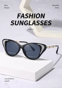 Μοντέρνα μαύρα γυαλιά ηλίου cat-eye με κομψούς χρυσούς βραχίονες αλυσίδας σε μπλοκ