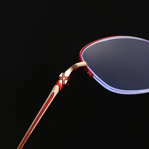 Dettaglio ravvicinato di occhiali da lettura anti-luce blu da donna con montatura rossa e oro.