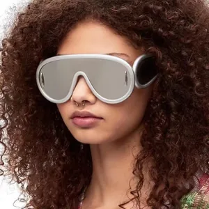 Dettaglio di occhiali da sole futuristici argentati indossati da una modella con capelli ricci