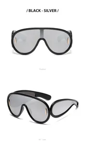 Viste dettagliate degli occhiali da sole Y2K futuristici con montatura nera e argento.