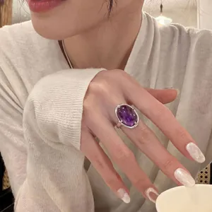 Nahaufnahme eines eleganten ovalen violetten Edelsteinrings mit verstellbarem Band.