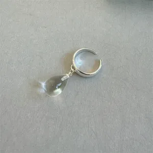 Nahaufnahme eines eleganten silbernen Rings mit klarem Wassertropfen-Kristallanhänger