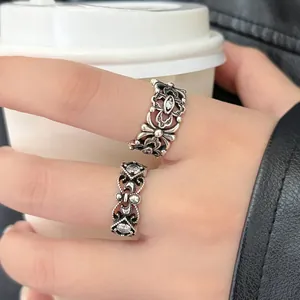 Close-up of retro hollowed-out Thai silver rings with floral carvings and zircon.