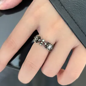 Detailed macro shot of a vintage hollow carved silver ring featuring clear zircons on hand