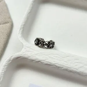 Macro detail view of a vintage openwork engraved ring featuring intricate floral patterns and stones
