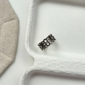 Macro view showing intricate hollowed floral patterns and vintage finish on Thai silver ring.